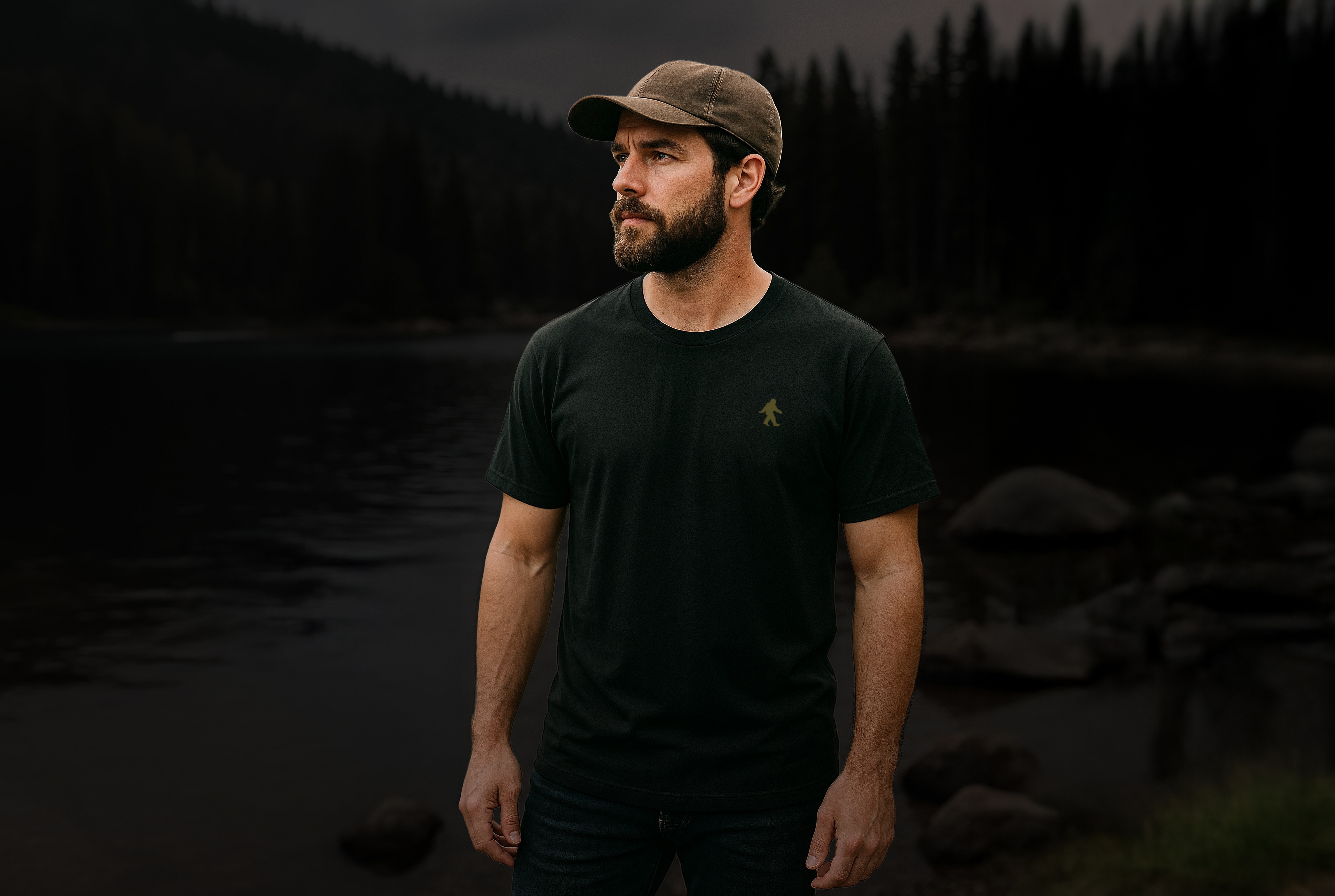 Man in The Real Bigfoot t-shirt and cap with a lake in the background.